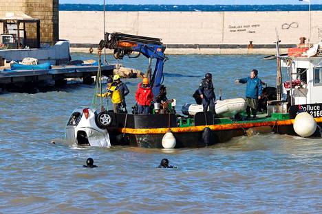Rescue workers raised submerged vehicles in the sea while searching for the missing on Sunday.