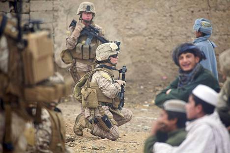 Yhdysvaltain merijalkaväen sotilaat Sienna De Santis ja Heidi Dean tervehtivät paikallisia lapsia Afganistanin Sanginissa lokakuussa 2010.