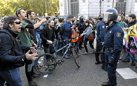 Mielenosoittajat huusivat mellakkapoliiseille mielenosoituksessa Madridissa.