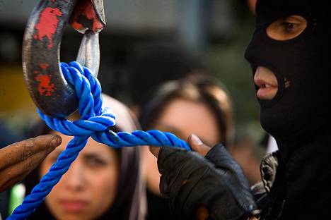 Iranin poliisin erikoisjoukkojen jäsen kokeili köyttä ennen julkista hirttämistä Teheranissa vuonna 2007.