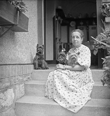 Dora Kallmus alias Madame d'Ora rakkaine koirineen vuoden 1935 tienoilla Anna-sisarensa omistaman Haus Dorannan portailla Frohnleitenissa Itävallassa. 