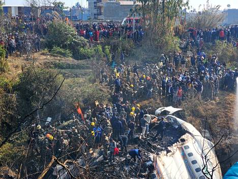 Matkustajalentokone putosi Nepalissa sunnuntaina. Kyydissä oli 72 ihmistä. Ihmiset kerääntyivät koneen luokse Pokharassa.