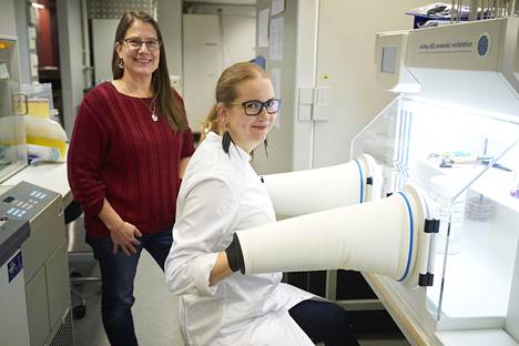 Reetta Satokari seuraa, kun  maisteriopiskelija Helena  Vähä-Mäkilä siirrostaa bakteereja  anaerobikaapissa. ”Bakteerit  ovat nopeampia kuin mitä  lääkekehitys. Koitamme saada  tauteja kiinni niin sanotusti."