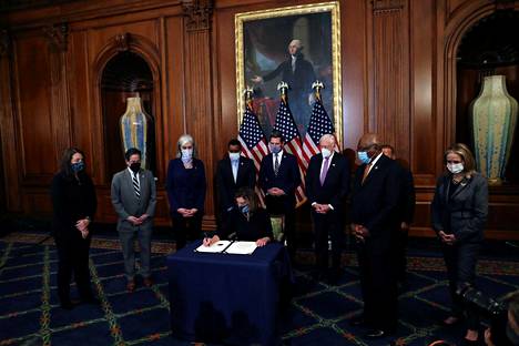 Edustajainhuoneen puhemies Nancy Pelosi allekirjoittaa virkarikossyytteen presidentti Donald Trumpia vastaan.
