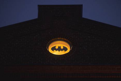 In the story, a bat pattern is projected into the sky when Batman is called for help.  Now the pattern can be seen as close to the sky as it is possible in this house, in the round attic window.