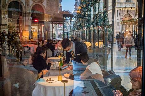 Ravintolatyöntekijä tarkasti asiakkaiden koronapassin milanolaisessa ravintolassa tammikuussa.
