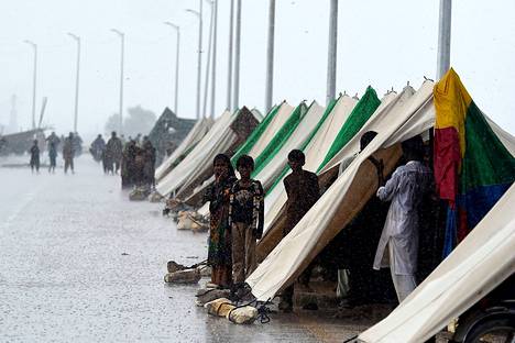 Ihmiset hakeutuivat sateelta suojaan tilapäisessä telttamajoituksessa Sindhin provinssissa. 