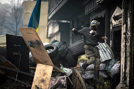 Oppositiota kannattava mielenosoittaja käveli barrikadilla Kiovassa lauantaina.