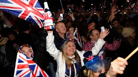 Ihmisiä juhlimassa brexitiä Parliament Squarella Lontoossa.