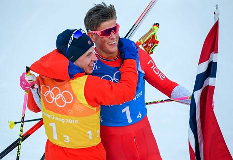 Simen Hegstad Krüger (vas.) ja Johannes Høsflot Klæbo lyttäävät hiihdon maailmancupin uudistukset. Kuvassa norjalaiskaksikko juhlii viestikultaa Pyeongchangin olympialaisissa 2018.