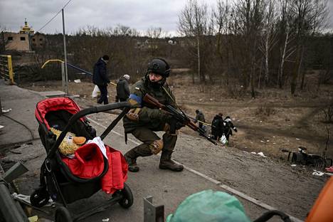 Люди убегают от российского вторжения в Ирпене. Март 2022 года. Фото: Арис Мессинис / AFP
