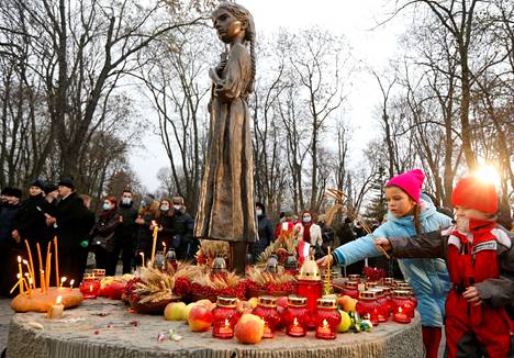 Lapset heittivät jyviä nälänhädän uhrien muistomerkille Kiovassa kaksi vuotta sitten. Holodomorin muistopäivää vietetään marraskuun viimeisenä sunnuntaina.