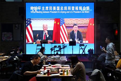Pekingiläisen ravintolan jättinäytöllä välitettiin kuvaa Joe Bidenin ja Xi Jinpingin videoneuvotteluista tiistaiaamuna paikallista aikaa.