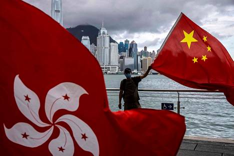 Mies heilutti Kiinan lippua Hongkongissa perjantaina, jolloin vietettiin saaren hallinnon luovuttamista Britannialta Manner-Kiinalle 25-vuotispäivää.