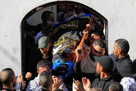 Palestiinalaiset kantavat Jeninin pakolaisleirillä kuolleen ihmisen ruumista 26. tammikuuta.