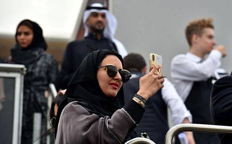 Saudiarabialainen nainen otti valokuvaa kännykkäkamerallaan ennen Formula E -autourheilukilpailua Riadissa joulukuussa.