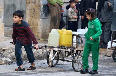 Pojat kuljettivat vesikanistereita Syyrian armeijan saartamalla kapinallisalueella Itä-Aleppossa lauantaina.