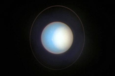 Uranus vuonna 2022. Kevään tulo on lisännyt vaaleaa pilvisyyttä selvästi pohjoisella napaseudulla. Planeetan navat ovat Uranuksella oudosti lähes ratatasossa, lähellä  päiväntasaajaa. 
