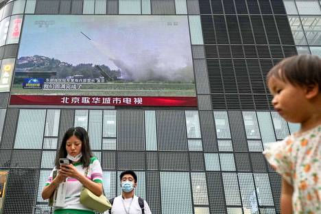 Ohjuksen laukaiseminen Kiinan sotaharjoituksissa näytettiin videonäytöllä Kiinan pääkaupungissa Pekingissä torstaina.