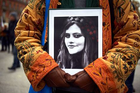 Mielenosoittaja pitää esillä Mahsa Aminin kuvaa Toulousessa Ranskassa 3. joulukuuta.