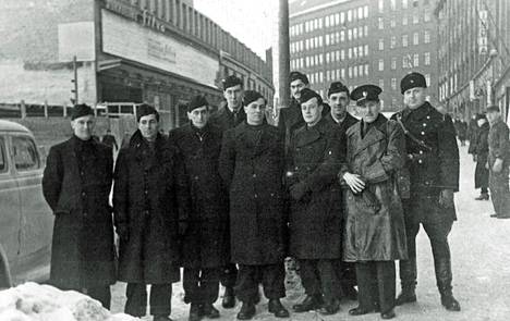 Brittivapaaehtoiset kuvattuna maaliskuussa 1940 Helsingissä Kaisaniemenkadulla. Anthony Gilkison on viiksekäs mies joukon takana. Kuvassa on ilmeisesti myös pari vieraita isännöinyttä suomalaista.