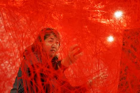 Taiteilija Chiharu Shiota Äärirajoilla-lankateoksensa sisällä Espoon modernin taiteen museo Emmassa. 