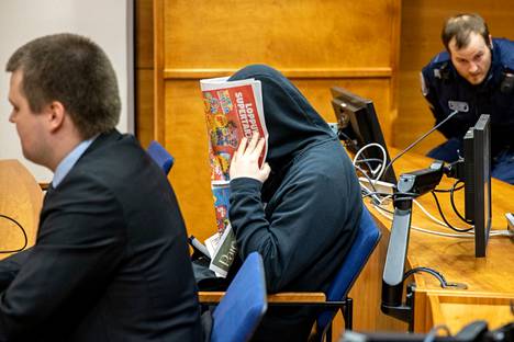 Murhasta syytetty mies peitti kasvonsa oikeudenkäynnin alkaessa Tampereella. 