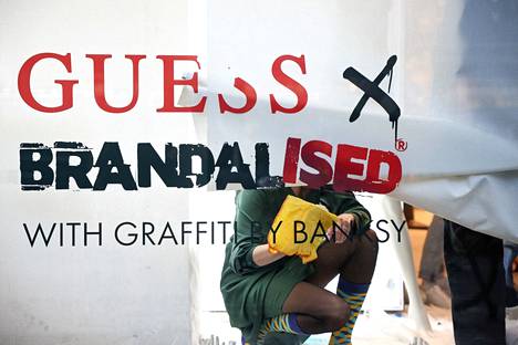 Guessin Lontoon-liikkeen työntekijä poistaa ikkunasomistusta 18. marraskuuta sen jälkeen, kun Banksy oli kehottanut varastamaan liikkeestä.