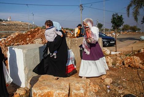 Naiset ylittivät saarron esteitä Qusrassa 13. marraskuuta.