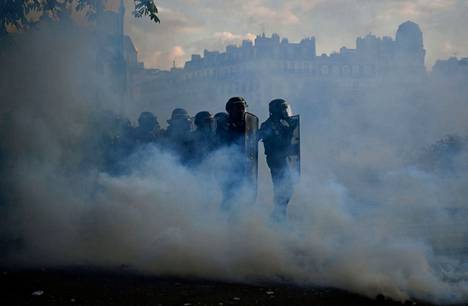 Mellakkapoliiseja kyynelkaasun keskellä Pariisissa maanantaina.
