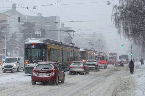 Kolme raitiovaunua seisoi Tukholmankadulla lumisateisessa Helsingissä maanantaina.