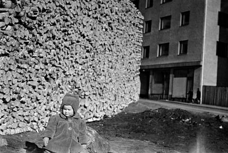 Pikkutyttö halkopinon edessä Helsingin Kalliossa vuonna 1943.