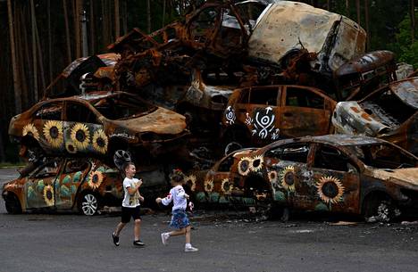  Lapset leikkivät Venäjän joukkojen tuhoamien autojen symbolisella hautausmaalla 9. elokuuta Irpinissä Ukrainassa. Autot olivat paikallisten taiteilijoiden koristelemia. 