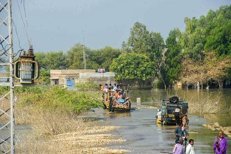 Lokakuussa 2022 maansisäiset pakolaiset yrittävät päästä eteenpäin tulvivalla kadulla Pakistanissa Sindhin provinssissa.