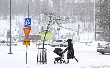 Jalankulkija työnsi lastenrattaita lumipyryssä Espoon keskuksessa lauantaina 11. maaliskuuta.