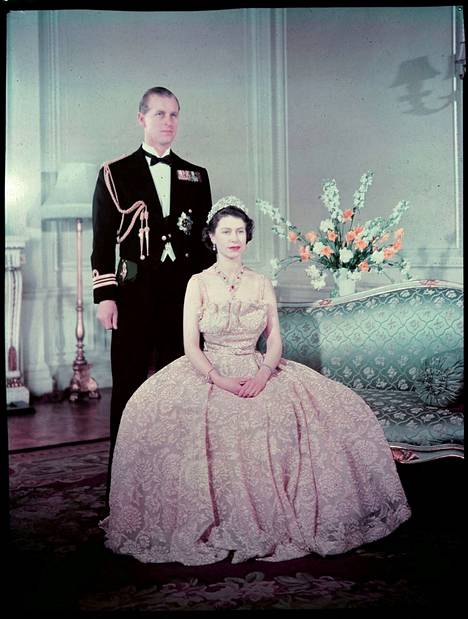 Kuningatar Elisabet ja prinssi Philip Buckinghamin palatsissa vuonna 1952. Elisabetillä on päällään vaaleanpunainen lyhythihainen mekko. Kruunajaisten jälkeen hänet nähtiin yleensä pitkähihaisissa asuissa. 