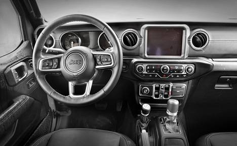 The design of the Wrangler cab follows the same angularity as the car’s outer shell. The window release buttons are especially below the center display and air conditioning switches.