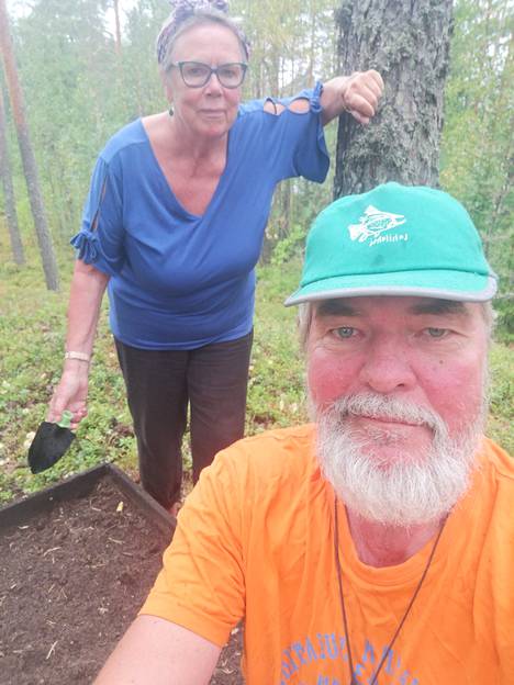 Riitta ja Ekku Mannio mökkitontillaan sen istutuslaatikon luona, josta löytyi perunoiden lisäksi tryffeleiksi epäiltyjä mukuloita.