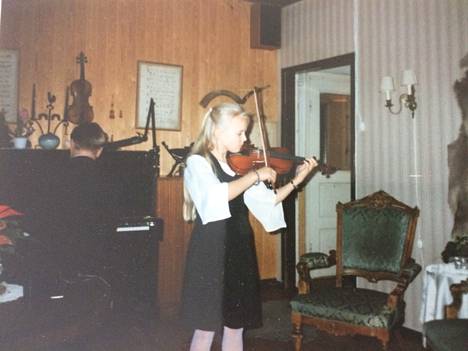 Aili Ikonen aloitti viulunsoiton viisivuotiaana ja sai edistyttyään esiintyä säännöllisesti perhejuhlissa. ”Vaatteista sekä hyacintista ja joulutähdestä päätellen kyseessä on  juuri jouluaatto, joita vietimme vuorovuosin kotona Korpilahdella tai serkkujeni luona Jyväskylässä.” Esitystä säestää hänen isänsä.