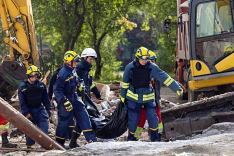 Palomiehet kantoivat raunioista löytynyttä ruumista Zaporižžjassa 10. lokakuuta.