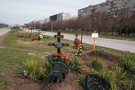Siviilien hautoja pitkälti tuhoutuneiden asuinrakennusten edustalla, autotien keskimaakaistalla Mariupolissa. Kuva on otettu 10. huhtikuuta.