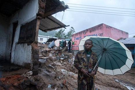 Paikallinen asukas seisoo sateenvarjon kanssa tuhon keskellä Malawin Blantyressä tiistaina.
