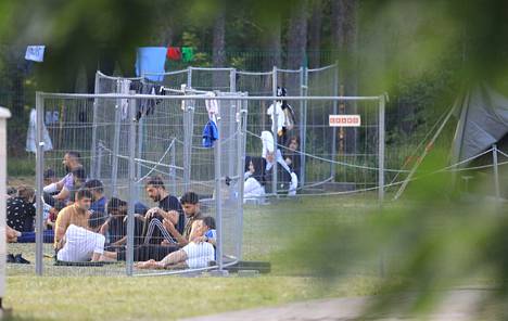 Liettua rajoittaa laittomasti maahantulleiden siirtolaisten liikkumista. Miehet tappoivat aikaa aidatussa telttaleirissä Kapčiamiestisin rajapitäjässä heinäkuussa.