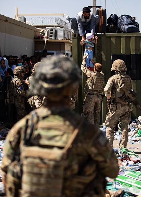 Afganistanilaismies ojensi lapsensa britannialaiselle laskuvarjojääkärille Kabulin lentokentällä 26. elokuuta.