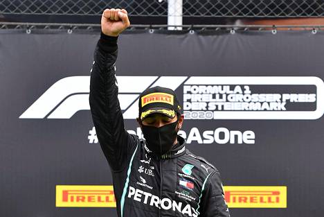 Lewis Hamilton nosti nyrkissä olevan kätensä ylös palkintopallilla Itävallan GP:n jälkeen.