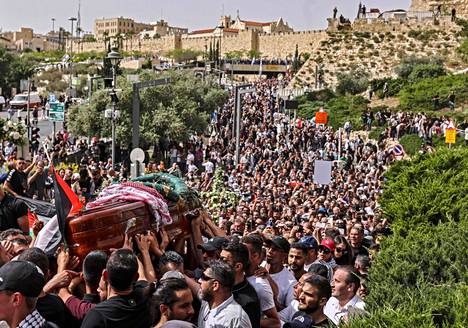 Palestiinalaiset kantavat toimittaja Shireen Abu Aklehin arkkua kirkolta hautausmaalle perjantaina Jerusalemissa.