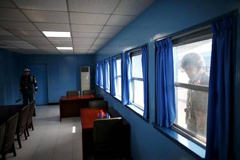 Pohjoiskorealainen rajavartija kurkkii neuvotteluhuoneen ikkunasta Koreoiden välisellä rajalla Panmunjomissa.