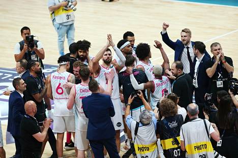 Basket Bonnin valmentaja Tuomas Iisalo (oik. ylhäällä) juhli joukkueensa kanssa Mestarien liigan välierävoittoa Unicaja Malagasta perjantaina.