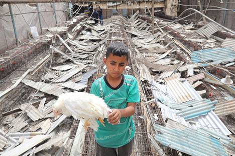 Palestiinalaiset tutkivat tuhoja Gazan kaupungissa lauantaina sen jälkeen, kun Israel oli iskenyt ilmaiskuin alueelle.
