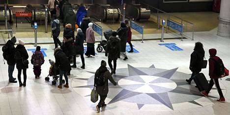Matkustajia Rautatientorin metroasemalla Helsingissä joulukuussa.